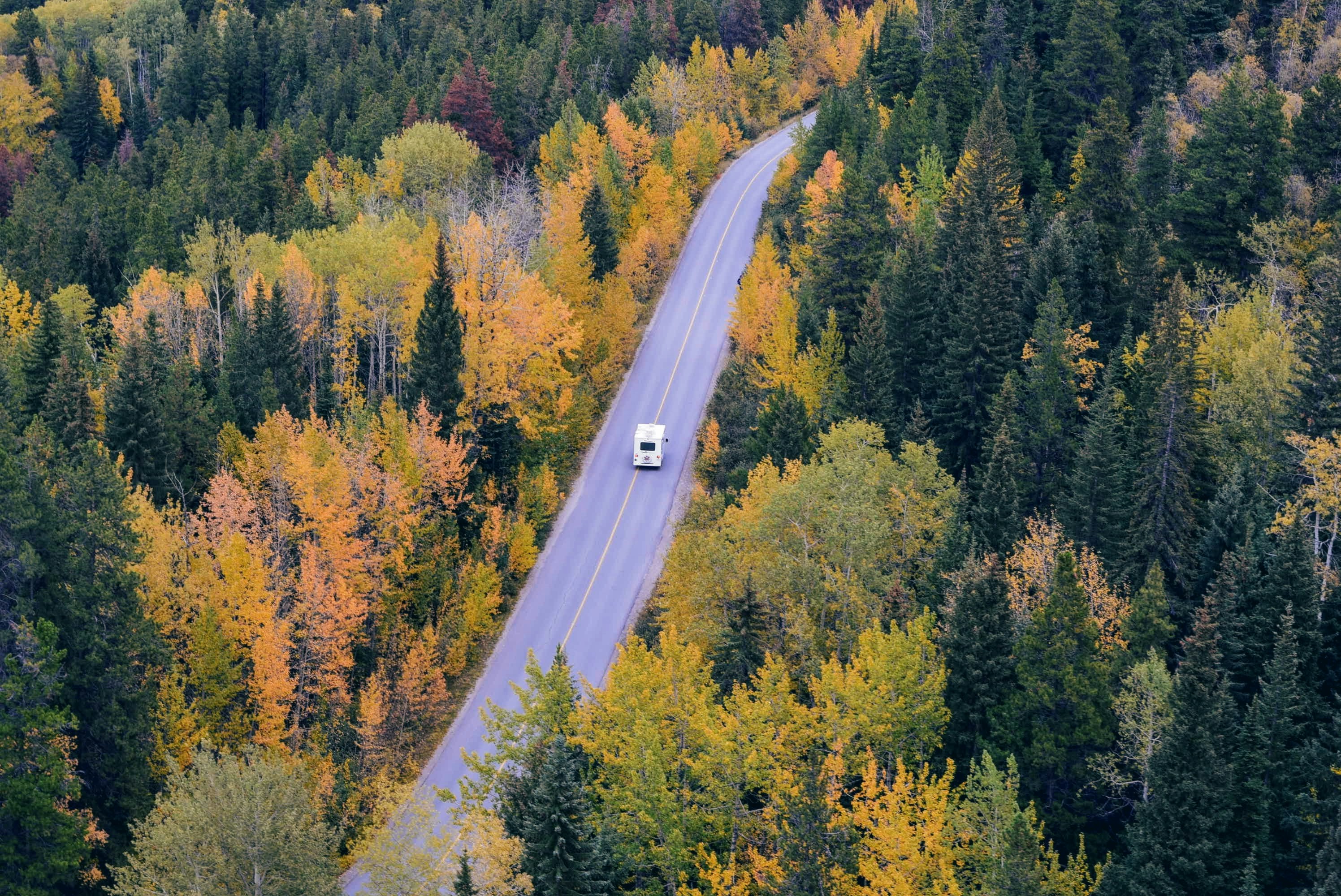 Motorhome driving through autumn landscape